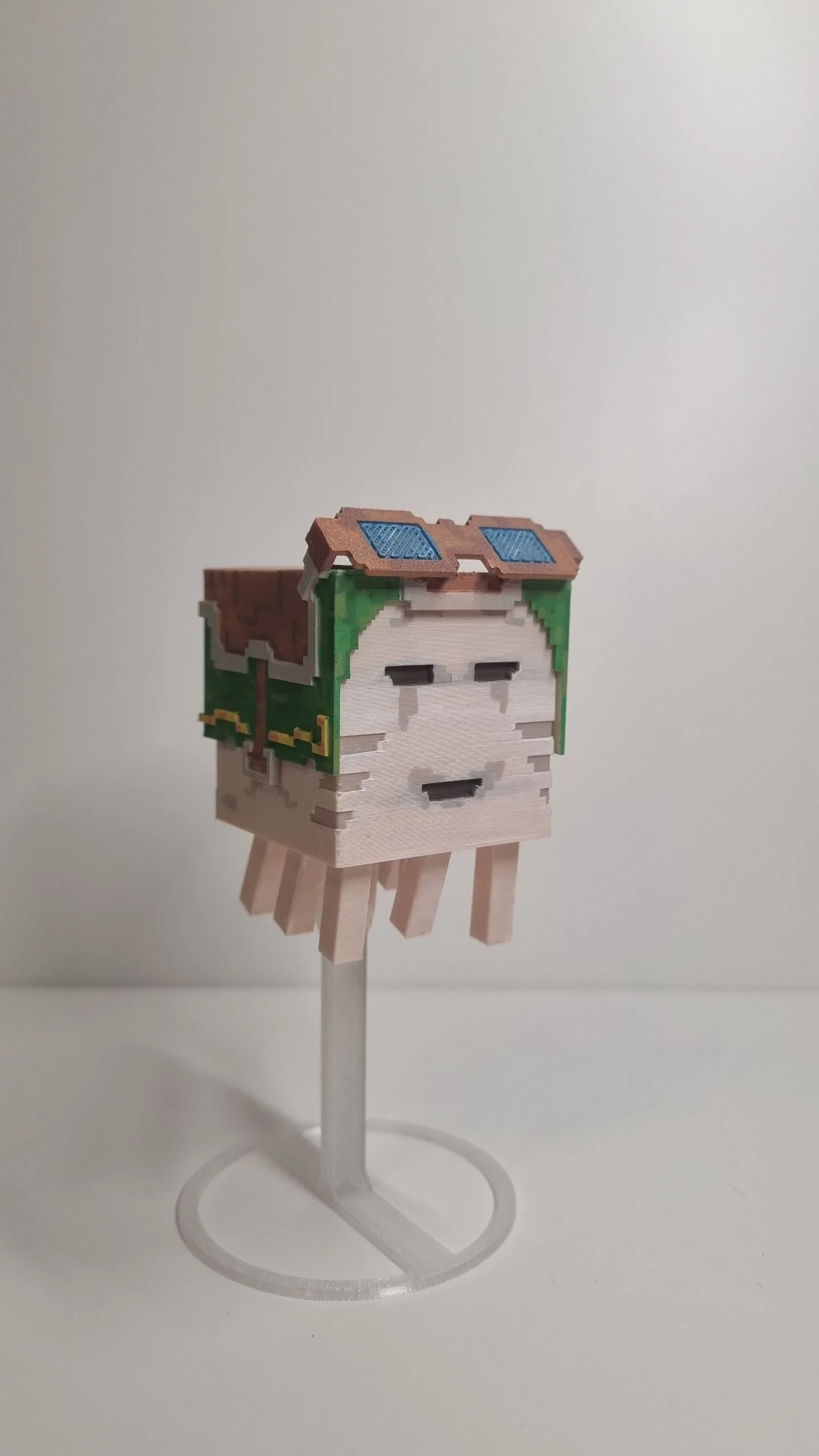 Фігурка Гаста з Minecraft у зеленій броні з окулярами на прозорій підставці, вигляд спереду